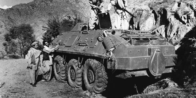 Rebel Muslim fighters inspect a Soviet tank captured in fighting with the Kabul government forces on September near Asmar, Afghanistan on Thursday, Dic. 27, 1979. The Kabul government of Hafizaullah Amin was overthrown by former Deputy Prime Minister Babrak Karmal. (AP Photo/Steve McCurry)