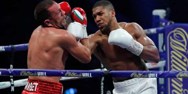 World Heavyweight boxing champion Britain's Anthony Joshua lands a blow on challenger Bulgaria's Kubrat Pulev during their Heavyweight title fight at Wembley Arena in London Saturday, Dec. 12, 2020.