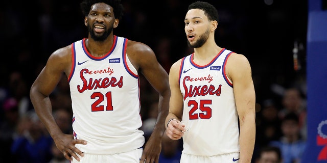In this Dec. 13, 2019, file photo, the Philadelphia 76ers' Ben Simmons, right, and Joel Embiid talk during an NBA basketball game against the New Orleans Pelicans in Philadelphia. (AP Photo/Matt Slocum, File)