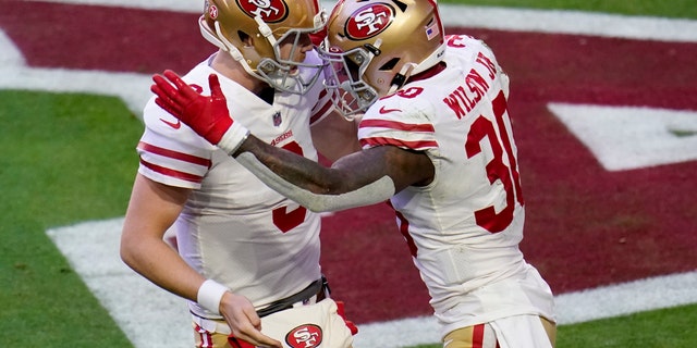 San Francisco 49ers running back Jeff Wilson (30) celebrates his touchdown against the Arizona Cardinals with quarterback C.J. Beathard (3) during the first half of an NFL football game, Saturday, Dec. 26, 2020, in Glendale, Ariz. (AP Photo/Ross D. Franklin)