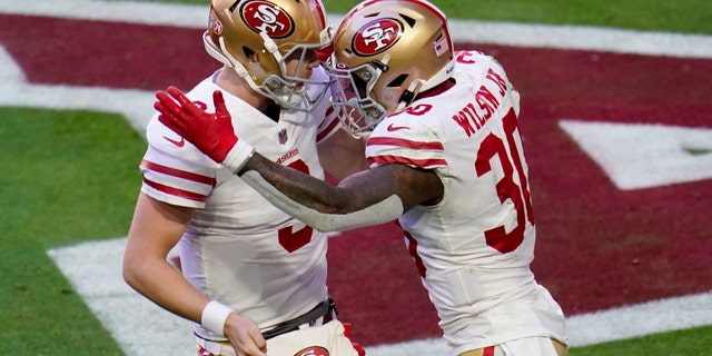 San Francisco 49ers running back Jeff Wilson (30) celebrates his touchdown against the Arizona Cardinals with quarterback C.J. Beathard (3) during the first half of an NFL football game, Saturday, Dec. 26, 2020, in Glendale, Ariz. (AP Photo/Ross D. Franklin)