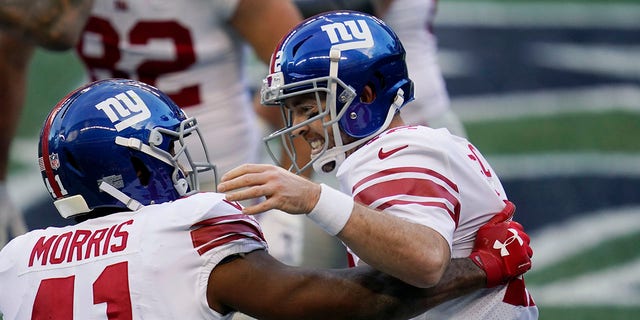 New York Giants quarterback Colt McCoy, right, greets running back Alfred Morris (41) after McCoy passed to Morris for the second touchdown of the second half of an NFL football game against the Seattle Seahawks, Sunday, Dec. 6, 2020, in Seattle. (AP Photo/Elaine Thompson)