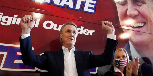 Republican candidate for Senate Sen. David Perdue and his wife, Bonnie, react during a campaign stop at Peachtree Dekalb Airport Monday, Nov. 2, 2020, in Atlanta. (AP Photo/John Bazemore)