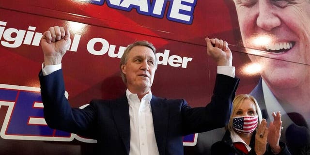 Republican candidate for Senate Sen. David Perdue and his wife, Bonnie, react during a campaign stop at Peachtree Dekalb Airport Monday, Nov. 2, 2020, in Atlanta. (AP Photo/John Bazemore)
