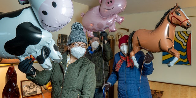 This photo shows the trio holding their own mini Macy's Thanksgiving Day Parade.