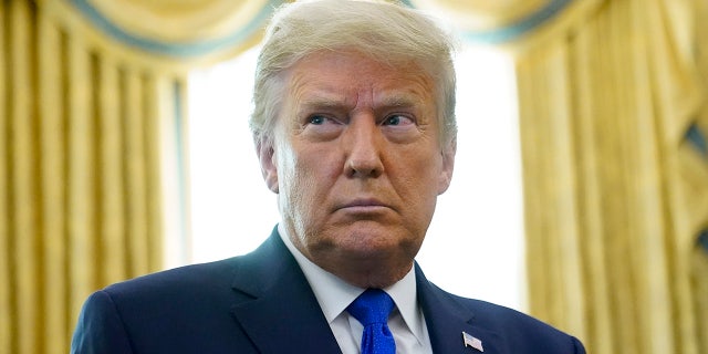 President Trump prepares to award the Presidential Medal of Freedom, the highest civilian honor, to Olympic gold medalist and former University of Iowa wrestling coach Dan Gable in the Oval Office of the White House, Monday, Dec. 7, 2020, in Washington. Trump has threatened to veto the National Defense Authorization Act if it does not include the repeal of Section 230. (AP Photo/Patrick Semansky)