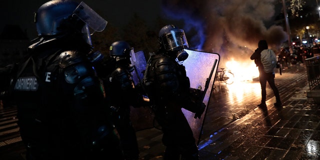Riot police officers advance during a demonstration, Dec. 5, in Paris. Thousands marched in protests around France on Saturday against a contested security bill with tensions quickly rising at the Paris march as intruders set fire to several cars, broke windows and tossed projectiles at police. (AP Photo/Lewis Joly)