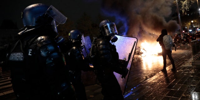 Riot police officers advance during a demonstration, Dec. 5, in Paris. Thousands marched in protests around France on Saturday against a contested security bill with tensions quickly rising at the Paris march as intruders set fire to several cars, broke windows and tossed projectiles at police. (AP Photo/Lewis Joly)