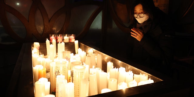 SEOUL, SOUTH KOREA - DECEMBER 31: A woman prays at the Chogey temple during the New Year Eve on December 31, 2020 in Seoul, South Korea. Seoul's city government has cancelled its annual New Year's Eve bell-ringing ceremony in the Jongno neighborhood for the first time since 1953. Normally an estimated 100,000 people would attend the ceremony, in which citizens ring a large bell in a traditional pavilion when the clock strikes midnight. Eeastern coastal areas have closed beaches and other spots where people typically gather on New Year's Day to watch the sunrise. (Photo by Chung Sung-Jun/Getty Images)