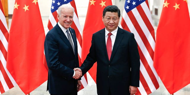 Chinese President Xi Jinping (R) shake hands with Joe Biden (L) inside the Great Hall of the People on December 4, 2013 