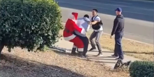 Image from video showing an undercover officer posing as Santa Claus apprehending a car thief suspect Thursday in Riverside, Calif. (Riverside Police Department)