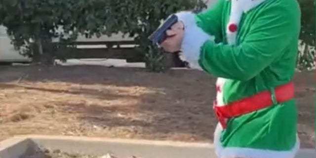 The image in the video of a secret officer dressed as a festive elf with a gun to a car thief suspect. (Riverside Police Headquarters)
