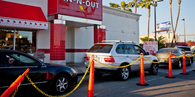 Los Ángeles, Estados Unidos - 13 de mayo de 2013  In-n-out Burger, restaurante de comida rápida en el aeropuerto de Los Ángeles.  Muchos autos están esperando en fila para ser atendidos en la pasarela del restaurante.