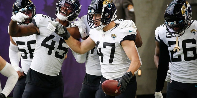 Jacksonville Jaguars linebacker Joe Schobert (47) celebrates with teammates after returning an interception 43-yards for a touchdown during the second half of an NFL football game against the Minnesota Vikings, Sunday, Dec. 6, 2020, in Minneapolis. (AP Photo/Bruce Kluckhohn)