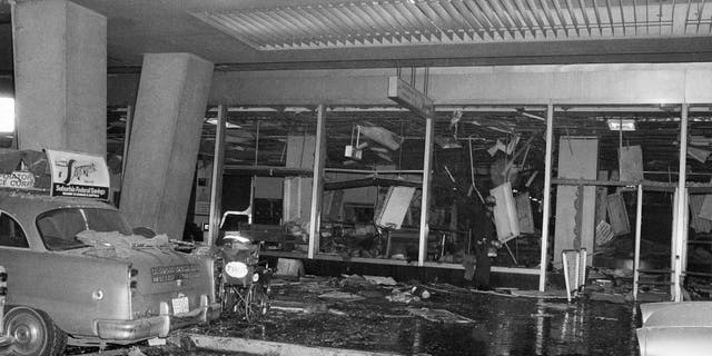 A solitary police rescue officer scans debris at New York's La Guardia Airport, Dec. 29, 1975, after a power explosion demolished a terminal baggage claim area. At least 11 persons were killed. (AP Photo)
