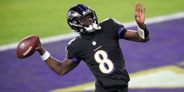 Baltimore Ravens quarterback Lamar Jackson pretends to throw the ball into the stands after scoring a touchdown on a keeper against the Dallas Cowboys during the first half of an NFL football game, Tuesday, Dec. 8, 2020, in Baltimore. (AP Photo/Nick Wass)