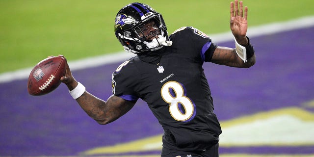 Baltimore Ravens quarterback Lamar Jackson pretends to throw the ball into the stands after scoring a touchdown on a keeper against the Dallas Cowboys during the first half of an NFL football game, Tuesday, Dec. 8, 2020, in Baltimore. (AP Photo/Nick Wass)