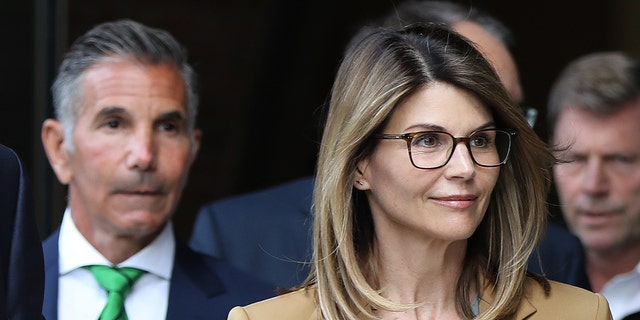 Lori Loughlin (right) and her husband Mossimo Giannulli (left) have both reported for their two- and five-month prison sentences, respectively. (Photo by Pat Greenhouse/The Boston Globe via Getty Images)