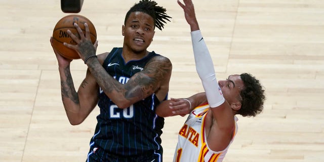 Orlando Magic guard Markelle Fultz (20) pulls in a rebound next to Atlanta Hawks guard Trae Young (11) during the second half of an NBA preseason basketball game Friday, Dec. 11, 2020, in Atlanta. (AP Photo/John Bazemore)