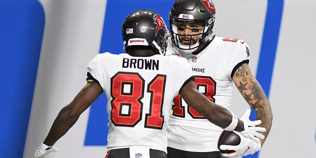 Tampa Bay Buccaneers wide receiver Mike Evans (13) celebrates his 27-yard reception for a touchdown with teammate wide receiver Antonio Brown (81) during the first half of an NFL football game against the Detroit Lions, Saturday, Dec. 26, 2020, in Detroit. (AP Photo/Lon Horwedel)