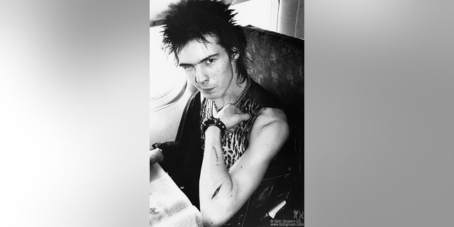 Sid Vicious of The Sex Pistols with a cut arm on a plane during US tour. January 1978.