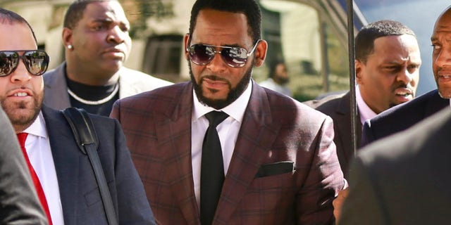 In this June 26, 2019, file photo, R&amp;B singer R. Kelly, center, arrives at the Leighton Criminal Court building for an arraignment on sex-related felonies in Chicago.