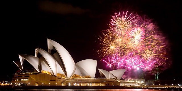 Sydney, Australia - April 9, 2014: Fireworks erupt behind the Sydney Opera House at night, as part of a Madama Butterfly opera being staged on Sydney Harbour.