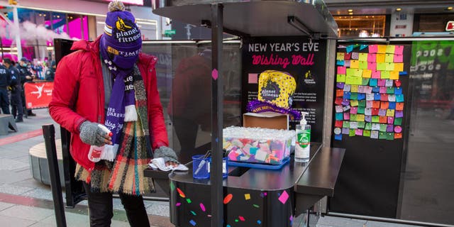 A worker in Times Square sanitizes the booth where people can write their new year wish on confetti that will shower the Crossroads of the World on New Year's Eve.