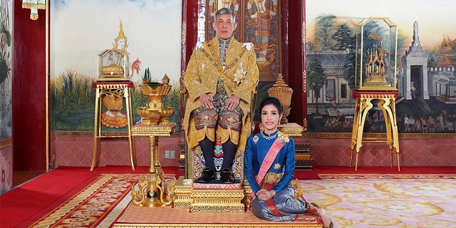 In this undated photo posted in 2019, on the Thailand Royal Office website, Thailand's King Maha Vajiralongkorn sits on the throne with his official consort Sineenatra Wongvajirabhakdi at the royal palace. (Thailand Royal Office via AP)