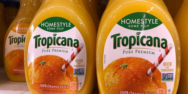 52 ounce bottles of Tropicana orange juice are displayed on a shelf at a grocery store.