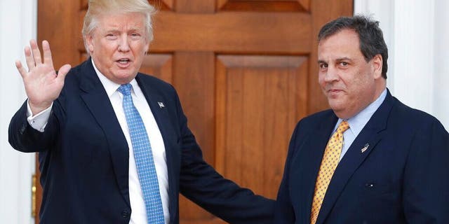 FILE - In this Nov. 20, 2016 file photo, then President-elect Donald Trump, left, waves to the media as New Jersey Gov. Chris Christie arrives at the Trump National Golf Club Bedminster clubhouse, in Bedminster, N.J. (AP Photo/Carolyn Kaster, File)