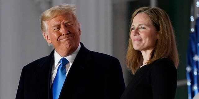 President Donald Trump and Amy Coney Barrett stand on the Blue Room Balcony after Supreme Court Justice Clarence Thomas administered the Constitutional Oath to her on the South Lawn of the White House in Washington, Monday, Oct. 26, 2020.