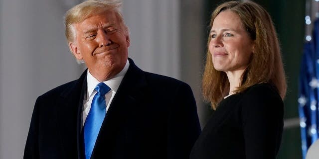 President Donald Trump and Amy Coney Barrett stand on the Blue Room Balcony after Supreme Court Justice Clarence Thomas administered the Constitutional Oath to her on the South Lawn of the White House in Washington, Monday, Oct. 26, 2020. 