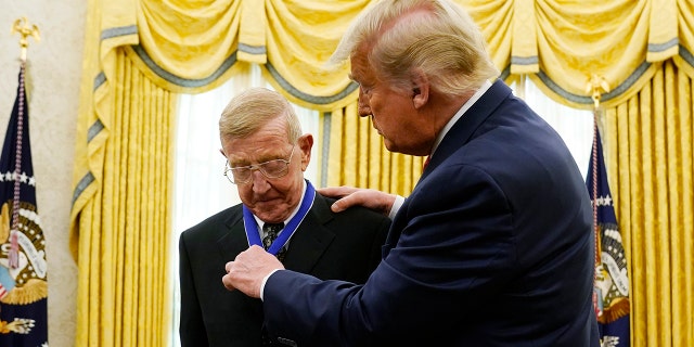 President Donald Trump awards the medal of Freedom, the highest civilian honor, to former college football coach Lou Holtz at the White House, Thursday, Dec. 3, 2020, in Washington. Holtz had a storied 34-year coaching career that included winning the 1988 national title at the University of Notre Dame. (AP Photo/Evan Vucci)