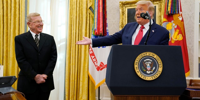 President Donald Trump prepares to award the medal of Freedom, the highest civilian honor, to former college football coach Lou Holtz at the White House, Thursday, Dec. 3, 2020, in Washington. Holtz had a storied 34-year coaching career that included winning the 1988 national title at the University of Notre Dame. (AP Photo/Evan Vucci)
