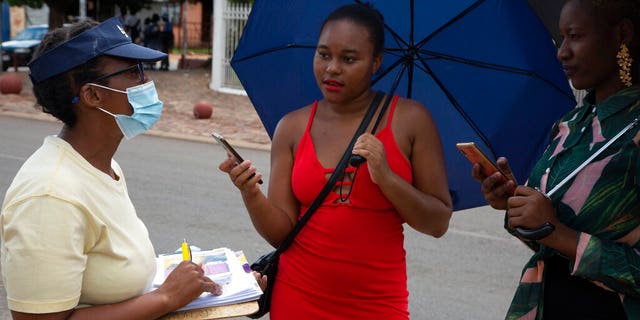 A counsellor, left, discusses with women the use of PrEP medication and the prevention of HIV infectionin in the Soshanguve Township, north of Pretoria, South Africa, Thursday, Nov. 26 2020. The successful trials of a new injectable drug that needs to be taken every eight weeks to prevent HIV infection is being lauded on World AIDS Day as a turning point for the fight against a global health threat that's been eclipsed by the coronavirus pandemic. (AP Photo/Denis Farrell)