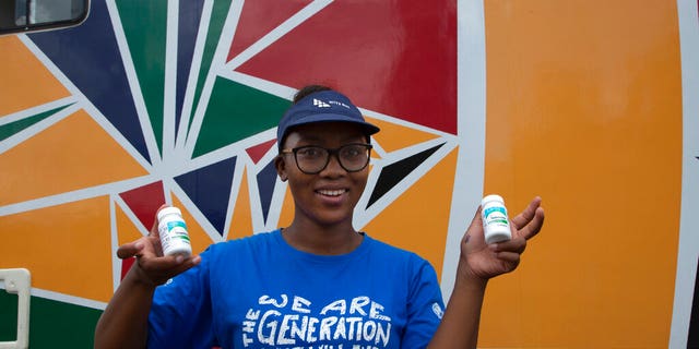 Khanyiswa Kwatsha, who runs a mobile clinic for the Reproductive Health and HIV Institute (RHI) background, shows containers of PrEP medication used in the prevention of HIV infectionin in the Soshanguve Township, north of Pretoria, South Africa, Thursday, Nov. 26 2020. The successful trials of a new injectable drug that needs to be taken every eight weeks to prevent HIV infection is being lauded on World AIDS Day as a turning point for the fight against a global health threat that's been eclipsed by the coronavirus pandemic. (AP Photo/Denis Farrell)