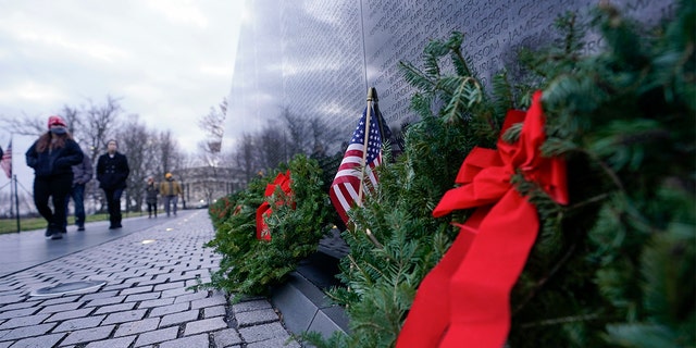 A wreath stands at the Vietnam Veterans Memorial as part of Wreaths Across America, Friday, Dec. 18, 2020, in Washington. (AP Photo/Manuel Balce Ceneta)