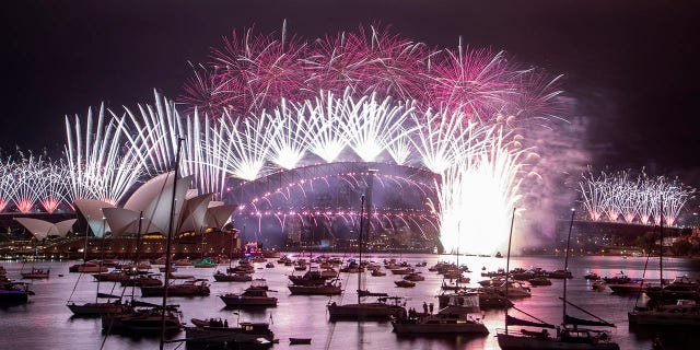 Fireworks explode over the Sydney Opera House and Harbour Bridge as New Year celebrations begin in Sydney, Australia, Friday, Jan. 1, 2021. Authorities advised revelers to watch the fireworks on television this year as the two most populous states, New South Wales and Victoria battle to curb new COVID-19 outbreaks. (AP Photo/Mark Baker)