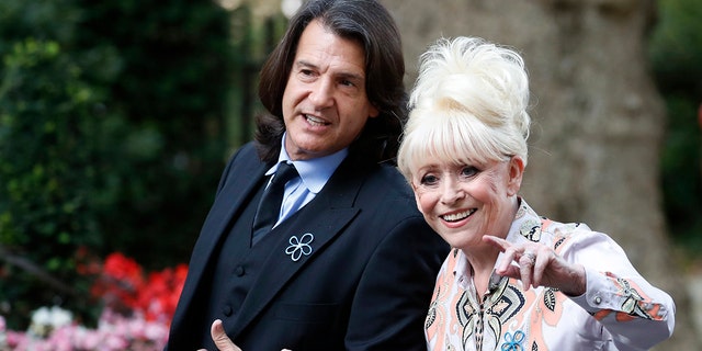 British actress Barbara Windsor waves as she arrives with her husband Scott Mitchell in Downing Street, London, to promote Dementia Care in 2019.