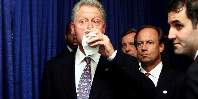 US President Bill Clinton (left) takes a last sip of his Diet Coke with aide Doug Band (right) before addressing a Democratic National Committee luncheon July 30, 2000, in Chicago. (TIM SLOAN/AFP via Getty Images)