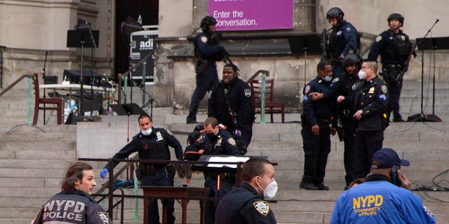 New York police officers carry a suspected gunman in a stretcher down the steps of Cathedral Church of St. John the Divine, Sunday, Dec. 13, 2020, in New York. (AP Photo/Ted Shaffrey)