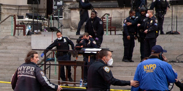 New York police officers carry a suspected gunman in a stretcher down the steps of Cathedral Church of St. John the Divine, Sunday, Dec. 13, 2020, in New York. (AP Photo/Ted Shaffrey)