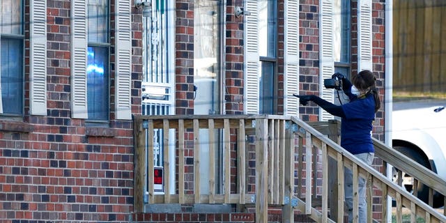 A member of the FBI Evidence Response Team photographs the entrance of a home Saturday, Dec. 26, 2020, in Nashville, Tenn. An explosion that shook the largely deserted streets of downtown Nashville early Christmas morning shattered windows, damaged buildings, and wounded three people. Authorities said they believed the blast was intentional. (AP Photo/Mark Humphrey)