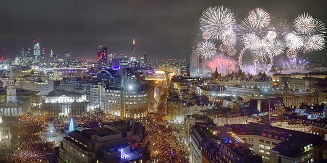 Cityscape of London at midnight on New Years eve. ThTrafalgar Square is traditionally where Londoners gather to celebrate the New Year and watch the distant fireworks along the River Thames