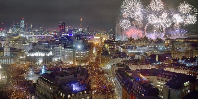 Cityscape of London at midnight on New Years eve. ThTrafalgar Square is traditionally where Londoners gather to celebrate the New Year and watch the distant fireworks along the River Thames