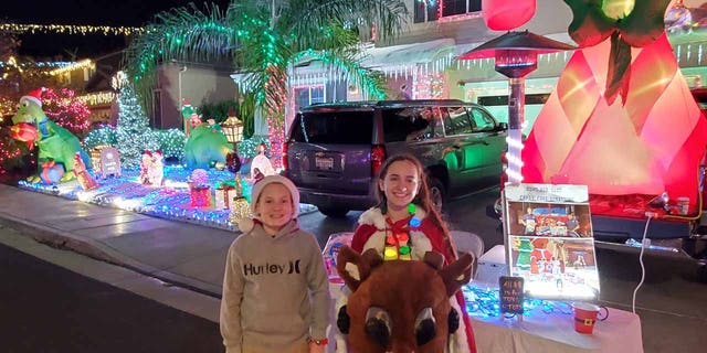 Troy and Cheyenne Valvo, 11-year-old twins, pose in front of their neighborhood Christmas light display. (Mike Valvo)