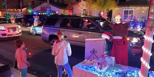 The pre-teens pass out candy canes to those both driving and walking through the light display. (Mike Valvo)
