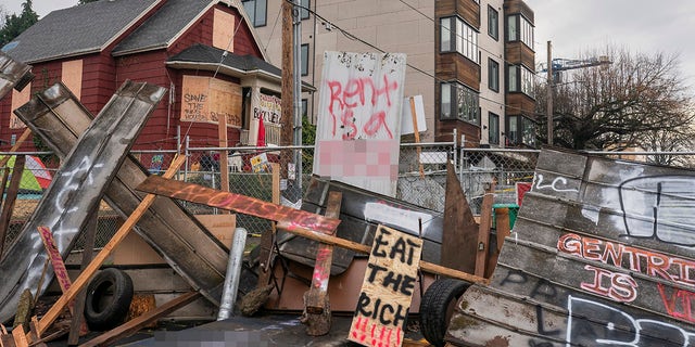 PORTLAND, OR - DECEMBER 10: (EDITOR'S NOTE: Image contains profanity). Barriers surround the Red House, whose residents are up for eviction, on December 10, 2020 in Portland, Oregon. Police and protesters clashed during an attempted eviction Tuesday morning, leading protesters to establish a barricade around the Red House. (Photo by Nathan Howard/Getty Images)