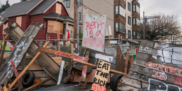 PORTLAND, OR - DECEMBER 10: (EDITOR'S NOTE: Image contains profanity). Barriers surround the Red House, whose residents are up for eviction, on December 10, 2020 in Portland, Oregon. Police and protesters clashed during an attempted eviction Tuesday morning, leading protesters to establish a barricade around the Red House. (Photo by Nathan Howard/Getty Images)